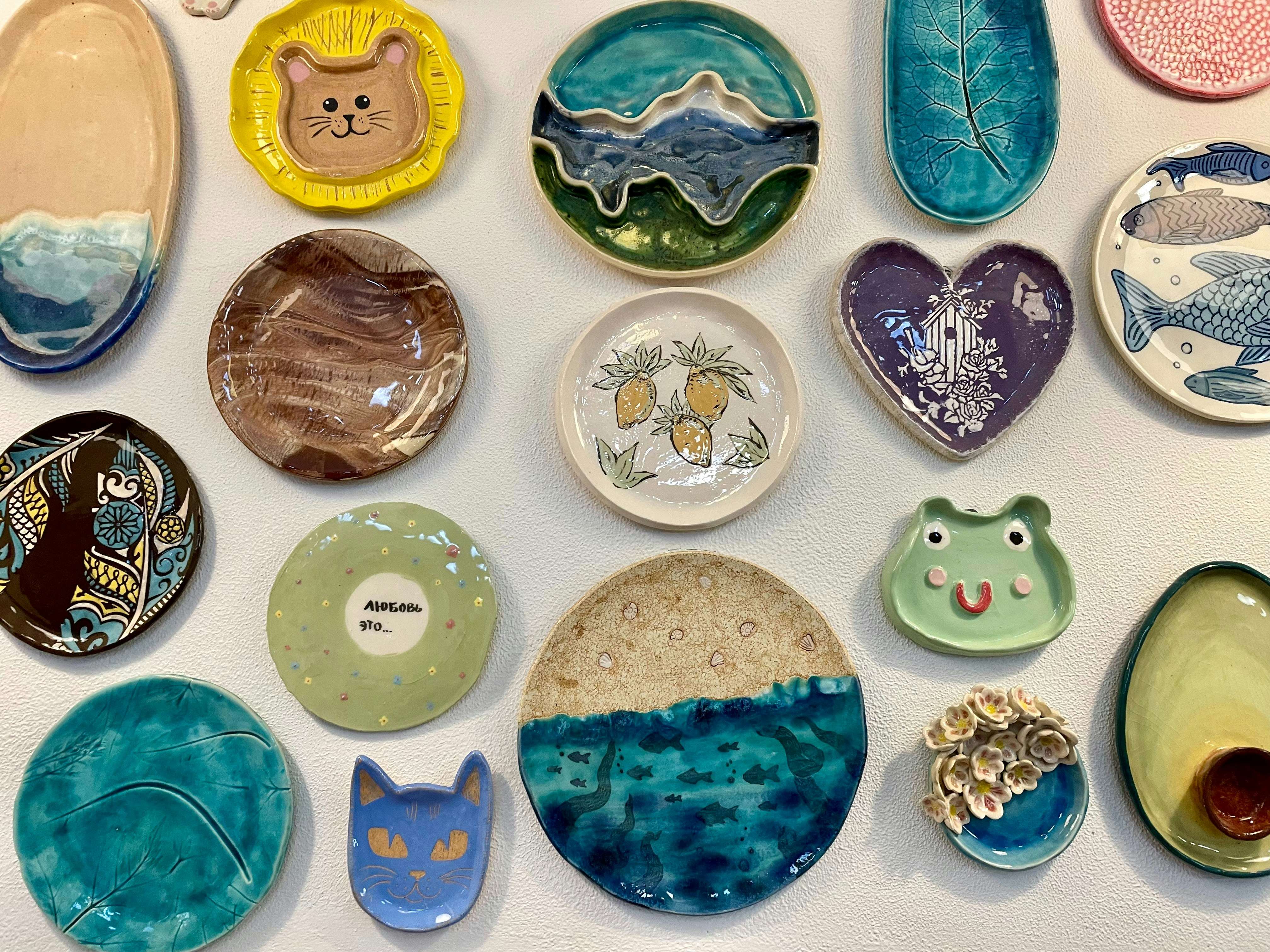 Birds-eye view of a group of people gathered around a table filled with pottery tools and clay projects.